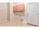 Laundry room with wooden cabinets and tile flooring at 7418 S 25Th Ln, Phoenix, AZ 85041