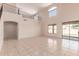 Living room featuring tiled floors, high ceilings, an open staircase, large windows, and sliding glass doors at 7418 S 25Th Ln, Phoenix, AZ 85041