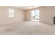 Bright living room features a sliding glass door and neutral carpet at 7418 S 25Th Ln, Phoenix, AZ 85041