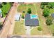 Aerial view of home on a large lot with in-ground pool, grass, trees, and storage building at 802 E Harwell Rd, Gilbert, AZ 85234