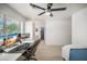 Bright bedroom with a modern ceiling fan, large windows, and a dedicated workspace featuring dual monitors at 802 E Harwell Rd, Gilbert, AZ 85234