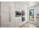 Sleek and stylish kitchen equipped with stainless steel appliances, custom cabinetry, and a bright window at 802 E Harwell Rd, Gilbert, AZ 85234