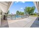 Inviting backyard pool enclosed with safety fence, complemented by lounge chairs and mature trees at 802 E Harwell Rd, Gilbert, AZ 85234