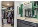 Stylish bathroom with a well-organized walk-in closet and a vanity featuring modern fixtures and storage at 850 S River Dr # 2065, Tempe, AZ 85281