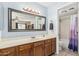 Bright bathroom with a single sink vanity, and a full bathtub with purple shower curtain at 850 S River Dr # 2065, Tempe, AZ 85281
