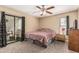 This bedroom boasts plush carpet, a ceiling fan, and a glass slider leading to an outdoor space at 850 S River Dr # 2065, Tempe, AZ 85281