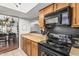 Functional kitchen design with wood cabinets, black appliances and views into living areas at 850 S River Dr # 2065, Tempe, AZ 85281