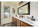 Bathroom featuring double sink vanity, wood cabinets, and a large framed mirror at 930 N Sandal Cir, Mesa, AZ 85205
