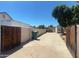 Long driveway leading to a secure wooden gate and white wall, ideal for private parking and additional storage at 930 N Sandal Cir, Mesa, AZ 85205