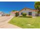Inviting one-story home with a lush front lawn and a convenient two-car garage at 930 N Sandal Cir, Mesa, AZ 85205
