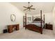 Spacious main bedroom with a four-poster bed, ceiling fan, and private door to back at 930 N Sandal Cir, Mesa, AZ 85205