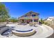 Spacious backyard featuring a patio, in-ground spa, fire pit and view of neighborhood lake at 9347 E Hillview Cir, Mesa, AZ 85207