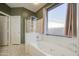 Bright bathroom features a soaking tub with a shower and large window for natural light at 9347 E Hillview Cir, Mesa, AZ 85207