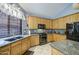 Kitchen features granite counters, oak cabinets, black appliances, and a mosaic backsplash at 9347 E Hillview Cir, Mesa, AZ 85207