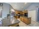 Bright kitchen features granite counters, a center island, oak cabinets, and black appliances at 9347 E Hillview Cir, Mesa, AZ 85207