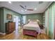 Comfortable main bedroom with wood floors, green walls, a ceiling fan, and a decorative bench at 9347 E Hillview Cir, Mesa, AZ 85207