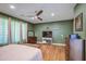 Main bedroom with wood floors, green walls, a ceiling fan, and a decorative bench at 9347 E Hillview Cir, Mesa, AZ 85207