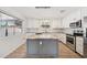 Stylish kitchen with gray island, white cabinets, granite countertops, stainless appliances and modern pendant lighting at 1017 S Allen --, Mesa, AZ 85204