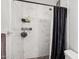 Updated shower featuring marble tile, black accents, and convenient shelving for toiletries at 1017 S Allen --, Mesa, AZ 85204