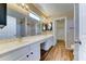 Bright bathroom features dual sinks, white cabinets, and wood-look floors at 10524 W Pima St, Tolleson, AZ 85353
