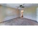 Bedroom with neutral walls, carpet, ceiling fan and doorway leading to ensuite bathroom at 10524 W Pima St, Tolleson, AZ 85353