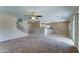 Open-concept living room with a ceiling fan, tile flooring, and a view into the kitchen area at 10524 W Pima St, Tolleson, AZ 85353