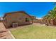 Large backyard featuring a green lawn, desert landscaping, and a charming fire pit, enhancing outdoor living at 11826 W Villa Hermosa Ln, Sun City, AZ 85373