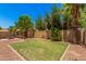 Landscaped backyard features a grassy area, mature trees, and a charming ambiance for outdoor enjoyment at 11826 W Villa Hermosa Ln, Sun City, AZ 85373