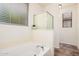 Bathroom features a bathtub, frosted glass shower, and natural lighting at 11826 W Villa Hermosa Ln, Sun City, AZ 85373