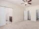 Open bedroom with carpet, ceiling fan, barn door to the bathroom, and closet at 11826 W Villa Hermosa Ln, Sun City, AZ 85373