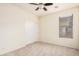 This bright carpeted bedroom includes a ceiling fan, window with blinds, and neutral walls at 11826 W Villa Hermosa Ln, Sun City, AZ 85373