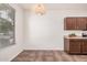 Bright dining area featuring tile floors, warm light fixture, and dark wood cabinets in view at 11826 W Villa Hermosa Ln, Sun City, AZ 85373