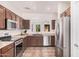 Contemporary kitchen with stainless steel appliances, wood cabinets, and open layout at 11826 W Villa Hermosa Ln, Sun City, AZ 85373