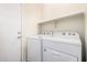 A tidy laundry room features a shelf and white appliances at 11826 W Villa Hermosa Ln, Sun City, AZ 85373