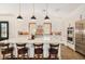 Stylish kitchen island with seating, pendant lights, stainless steel appliances, and brick accents at 12058 N Loma Linda St, Surprise, AZ 85388