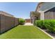Lush backyard with vibrant artificial turf and privacy hedges, great for outdoor enjoyment at 12109 W Tether Trl, Peoria, AZ 85383
