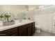 Bathroom featuring a single sink vanity with a mirror, dark wood cabinets, and a shower at 12109 W Tether Trl, Peoria, AZ 85383
