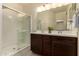 Bathroom featuring a double sink vanity with dark wood cabinets and a walk-in shower with glass door at 12109 W Tether Trl, Peoria, AZ 85383