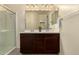 Bathroom featuring a double sink vanity with dark wood cabinets and a walk-in shower with glass door at 12109 W Tether Trl, Peoria, AZ 85383
