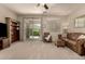 Spacious living room with neutral carpet, ceiling fan, sliding glass doors, and comfortable seating at 12109 W Tether Trl, Peoria, AZ 85383