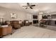 Spacious living room with modern furniture, ceiling fan, and adjacent kitchen with dark cabinets at 12109 W Tether Trl, Peoria, AZ 85383