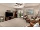 Comfortable living room with neutral carpet, ceiling fan, sliding glass doors, and abundant natural light at 12109 W Tether Trl, Peoria, AZ 85383