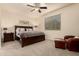 Comfortable bedroom with a queen-sized bed, bedside tables, a leather chair, and a ceiling fan at 12109 W Tether Trl, Peoria, AZ 85383