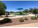 Community playground with shade cover, slides, and play equipment set in decorative rock and turf at 12109 W Tether Trl, Peoria, AZ 85383
