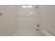 Bathroom bathtub and shower space featuring white tiling, built in shelving and modern hardware at 125 N 22Nd Pl # 5, Mesa, AZ 85213