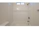 Bathroom bathtub and shower space featuring white tiling, built in shelving and modern hardware at 125 N 22Nd Pl # 5, Mesa, AZ 85213