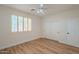 Bedroom featuring wood floors, bright natural light through shuttered windows, and a ceiling fan at 125 N 22Nd Pl # 5, Mesa, AZ 85213