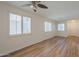 Bright living room featuring a ceiling fan, plantation shutters, and wood-look floors at 125 N 22Nd Pl # 5, Mesa, AZ 85213