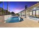 A stunning backyard featuring a sparkling pool with water features, a covered patio, and comfortable outdoor seating at 12638 E Cortez Dr, Scottsdale, AZ 85259
