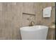 Close-up of a modern soaking tub with gold fixtures and custom tile work in a glass shower at 12638 E Cortez Dr, Scottsdale, AZ 85259